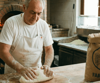Pizzaiolo ugniata ciasto na pizzę z mąki 00.