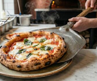 Pizzaiolo nakłada na talerz tradycyjną pizzę neapolitańską.