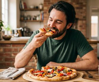 Mężczyzna je pizzę przygotowaną na mące kukurydzianej.