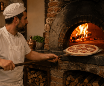 Pizzaiolo wkłada pizzę do pieca opalanego drewnem.