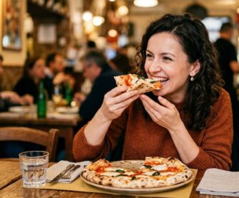 Kobieta je pizzę neapolitańską.
