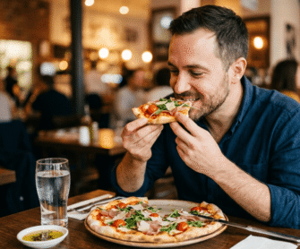 Mężczyzna je pizzę bezglutenową zrobioną na mące ryżowej.